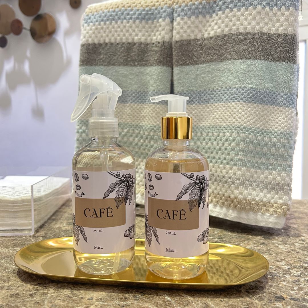 Kit de mist y jabón de café de Vnat, frascos de 250 ml sobre una bandeja dorada en un baño elegante con toallas de fondo.
