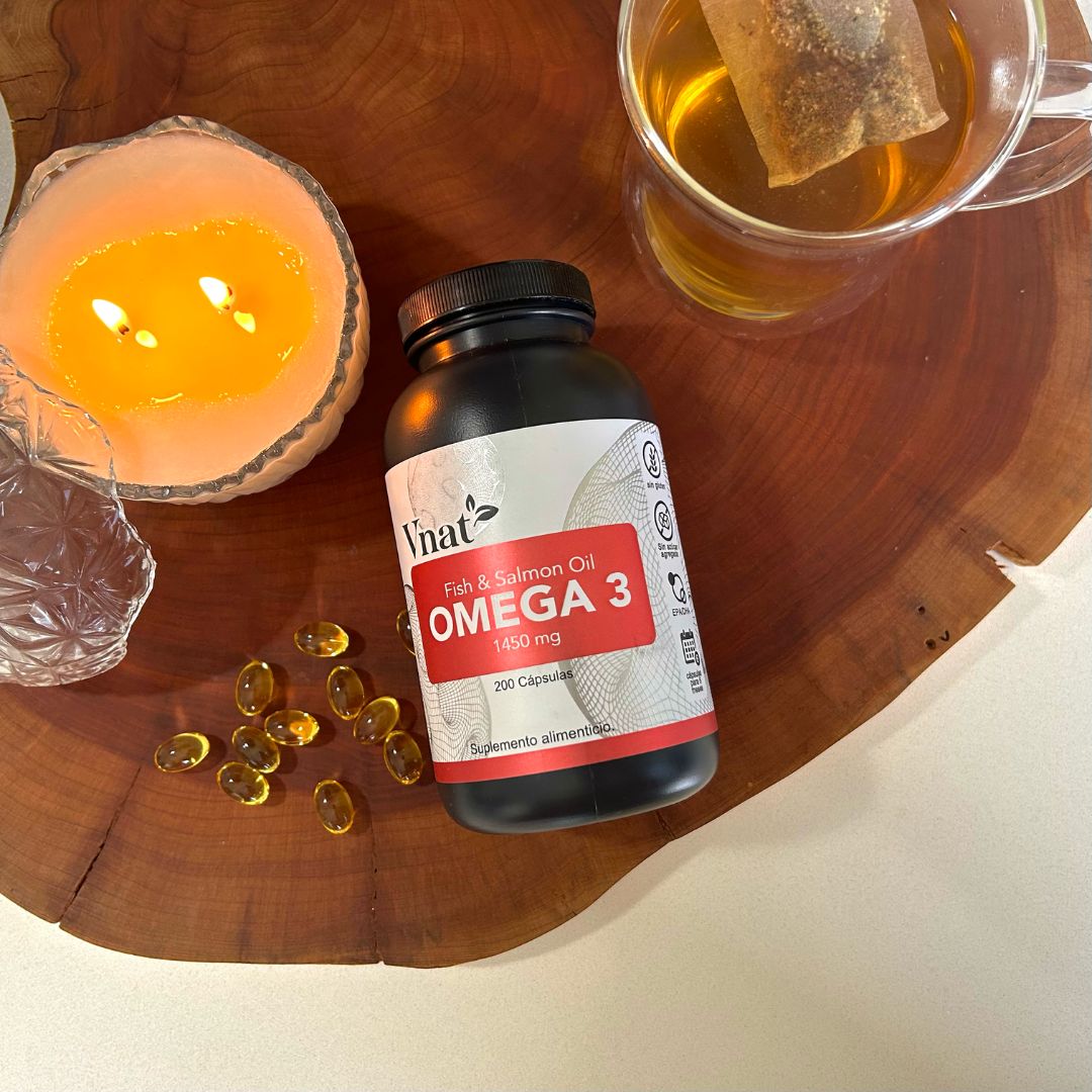 Bote de Omega 3 Fish and Salmon Oil 1450mg con 200 cápsulas de Vnat al lado de una vela aromática y una taza de té